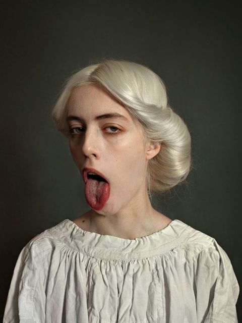 a woman sticking out her tongue with white hair