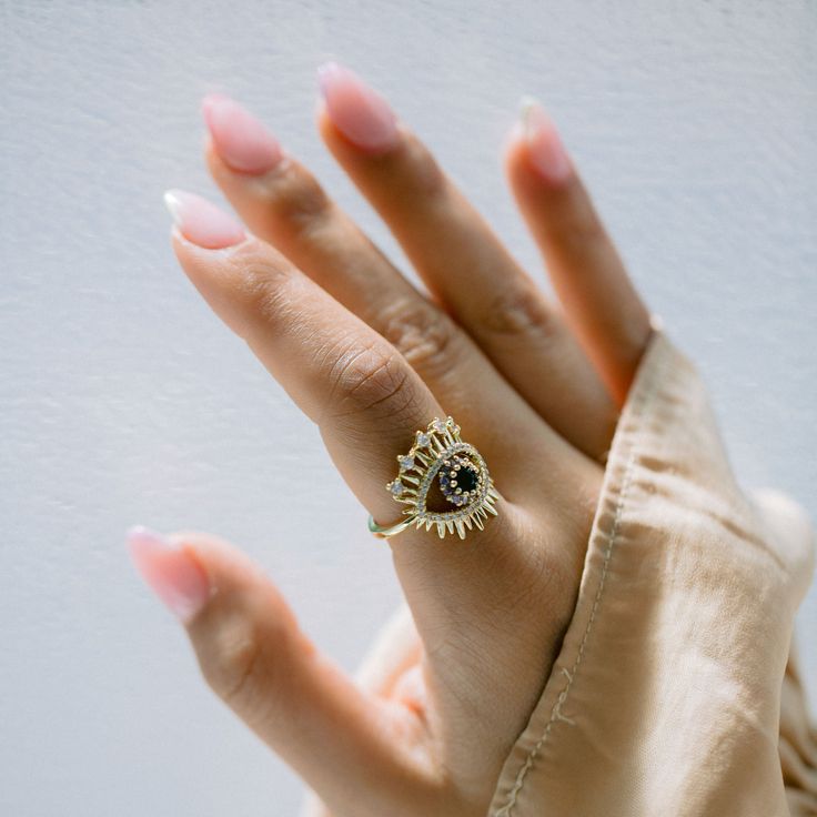 Crafted of gold and Brazilian zircon, this is not just any ring, but also an enchantingly beautiful means to ward off negative will. Materials: Finish: 18K gold platedCore: Titanium steelGemstone: Brazilian zirconSize: Adjustable, W: 2.1 cm x H: 1.8 cm 14k Gold Diamond Ring With Diamond Eyes, Gold Plated Gemstone Crystal Ring, Gold-plated Gemstone Crystal Ring, Gold-plated Crystal Ring With Gemstone, Tarnish Resistant 14k Gold Crystal Ring As Gift, 14k Gold Tarnish-resistant Crystal Ring As Gift, Gold-tone Topaz Open Ring For Promise, Gold Topaz Open Ring For Promise, Tarnish-resistant 14k Gold Crystal Ring For Gifting