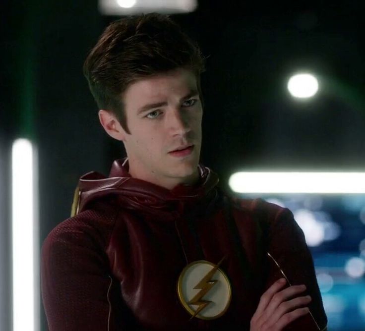 the flash standing with his hands on his chest