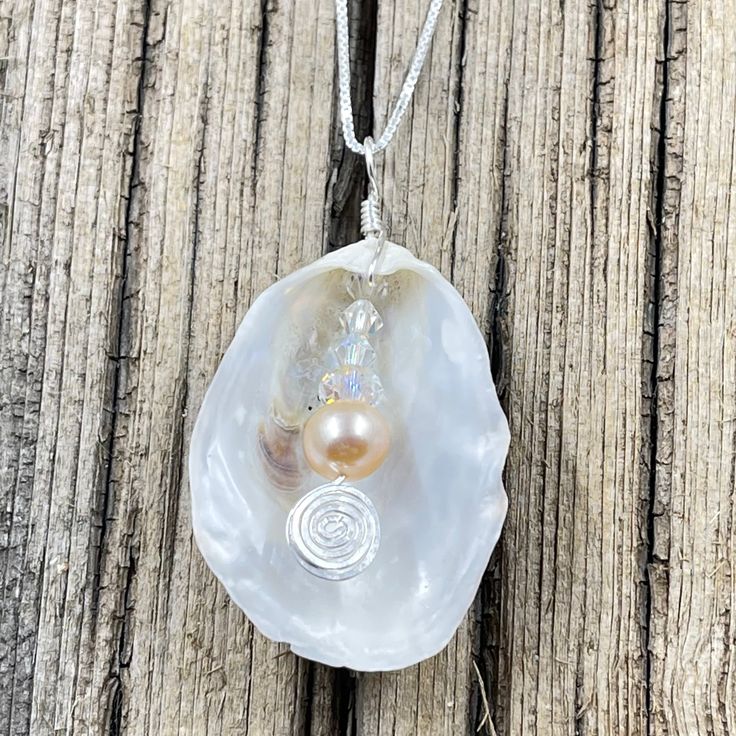 This beautiful pendant is made from a natural white oyster shell found on the beaches in the Cape May area. A spectacular metallic fresh water pearl is nestled inside the oyster shell showing off the treasure inside. The shell was then wire wrapped with sterling silver wire. The pendant measures 2 inches in length from the top of the bail and 1 inches wide. The pendant is on a 16" sterling silver box chain but other lengths are available in the below options. Cape May, Button Jewelry, Fresh Water Pearl, Shell Art, Silver Box, Shell Jewelry, Oyster Shell, Box Chain, Wire Wrap