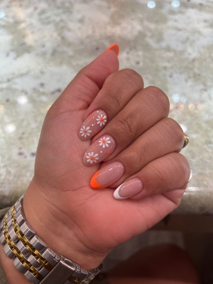 summer nails #flowers #orange #almondnails Summery Flowery Nails, Pastel Orange Nails With Flowers, Orange Nails White Flowers, Almond Nails Orange French Tip, Orange And Flower Nails, Orange And White Short Nails, Summer French Tips With Flowers, Orange Nails Acrylic Square, White And Orange French Tip Nails