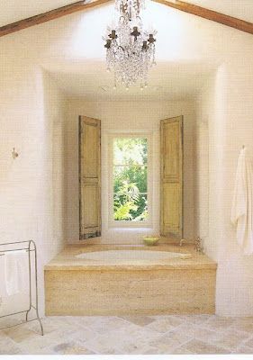 a bath room with a chandelier and a window