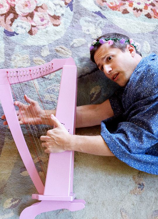 a man laying on the floor with a pink harp