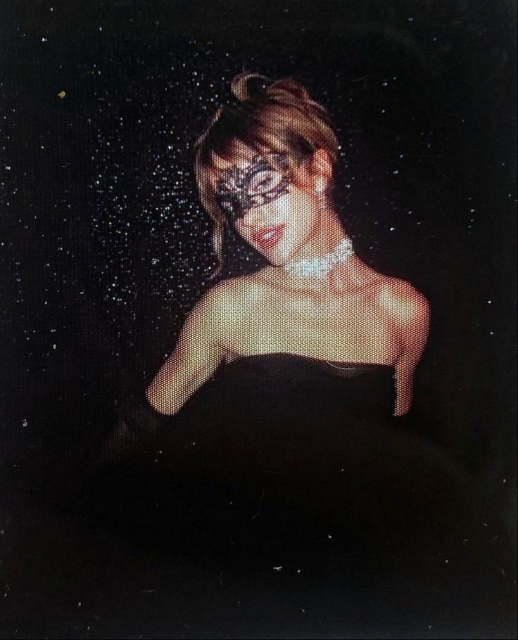 a woman in a black dress is posing for the camera with glitter on her face