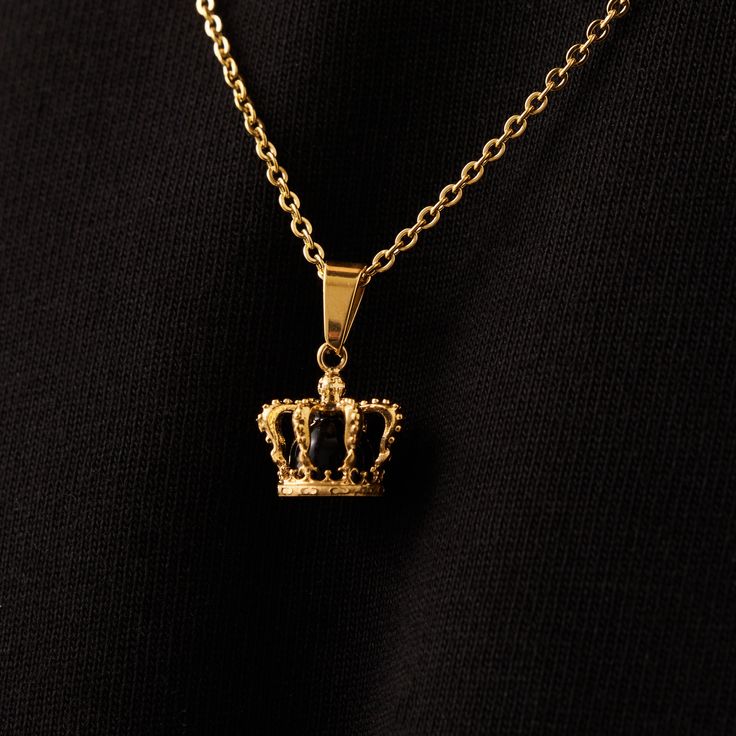 Your kingdom. Your rules. A solid onyx stone sits encased within an intricate 18K Gold crown, marking it as one of our most detailed and must-have pendants to date. This piece boasts ultra-durable, scratch-resistant plating and hangs regally upon a 3mm Gold Link Chain - a true standout of the King's Collection. For a seamless look, effortlessly stack it alongside the 18K Gold Crown Band Ring and any Gold Bracelet of your choice. Included: Full Lifetime Warranty ✓ 18K Gold & 316L Stainless Steel✓ Luxury Crown Design Gold Jewelry, Luxury Gold Jewelry With Crown Design, Luxury Gold Crown Design Jewelry, Luxury Gold Crown Jewelry, Luxury Yellow Gold Crown Jewelry, Luxury Yellow Gold Crown-shaped Jewelry, Regal Gold Jewelry With Crown Design, Classic Gold Crown Jewelry, Luxury Crown Design Jewelry For Formal Occasions