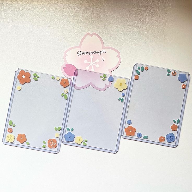 three blank cards with flowers and leaves on them, one has a pink flower in the middle