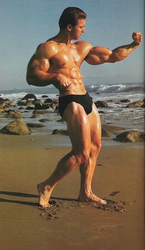 a man standing on top of a beach next to the ocean