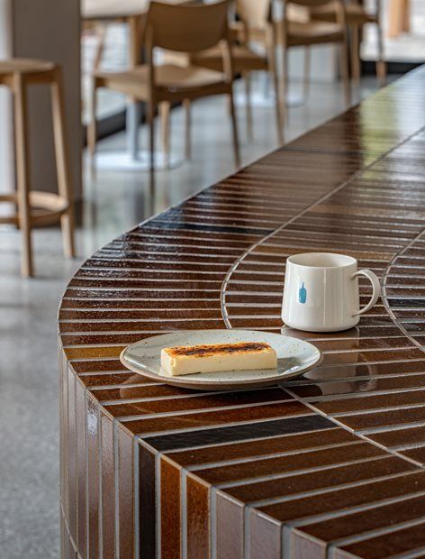 a table with a plate of food and a coffee cup on it next to some chairs