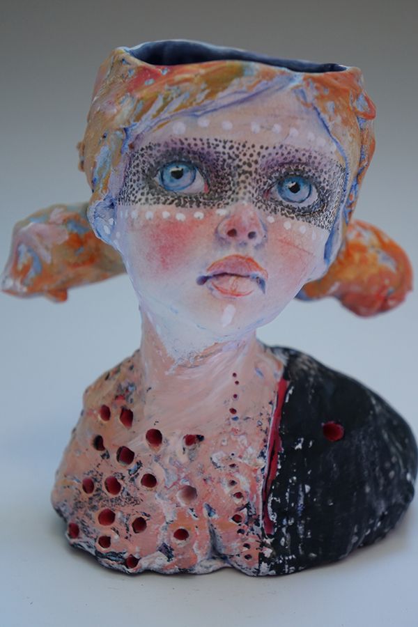 a ceramic sculpture of a woman with blue eyes