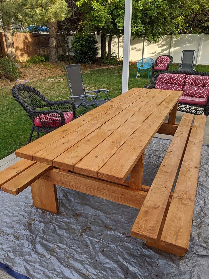 a wooden picnic table sitting on top of a patio