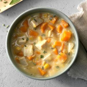 a bowl of chicken and vegetable soup on a table