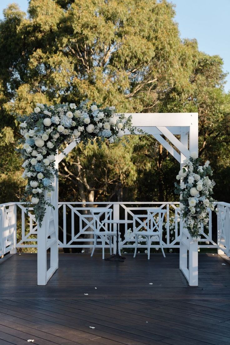 an outdoor wedding setup with white flowers and greenery