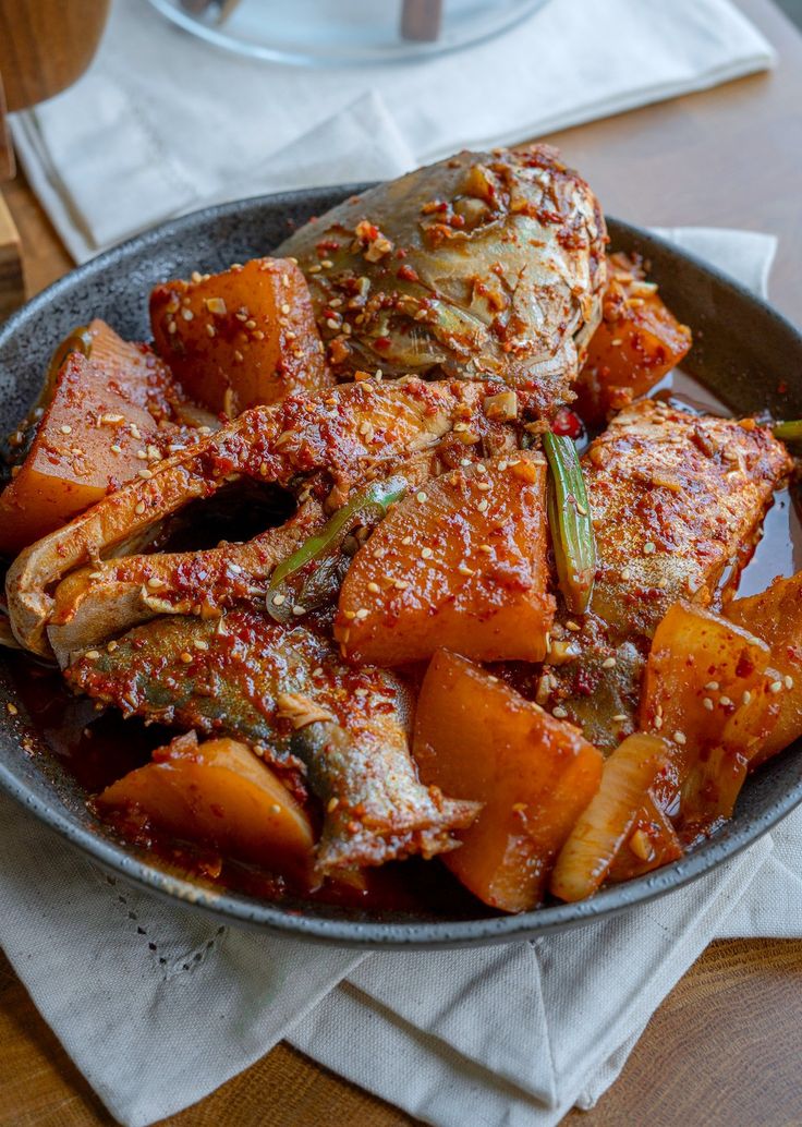 a bowl filled with meat and vegetables on top of a table