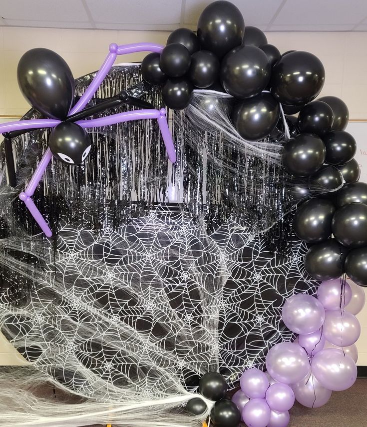 black and white balloons in a basket with streamers on the floor next to it