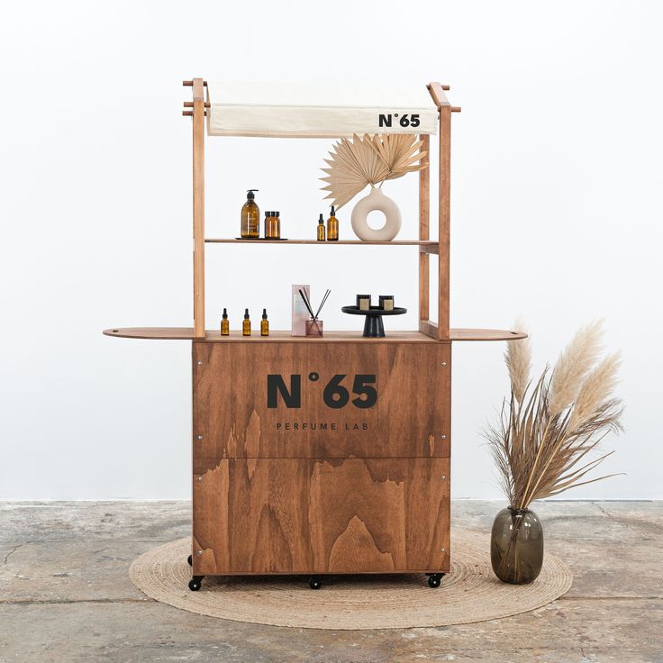 a wooden stand with bottles on it next to a potted plant and a vase