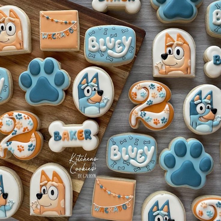 decorated cookies are arranged on a wooden board