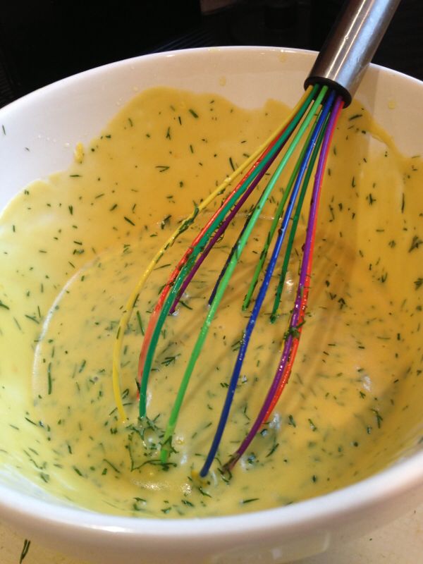 a white bowl filled with yellow sauce and colorful whisks in it, next to the words mustard and dill sauce