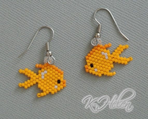 two small yellow fish earrings with silver earwires on top of a gray surface