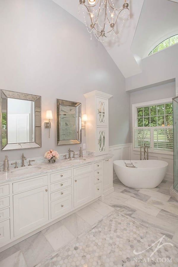 a large white bathroom with two sinks and a bathtub in it's center