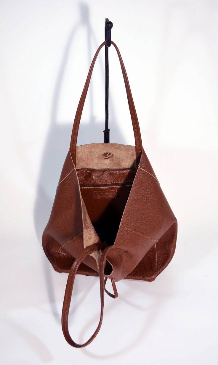 A lightweight and spacious Leather Shopper Bag-Tan you can use for your office, gym and after-hours essentials while still looking stylish. Handmade from supple calfskin Italian leather, the versatile look features over-the-shoulder handles and minimal detailing. Raw edges and no lining makes this style super light and easy to fold when traveling. Inside is a zippered document pouch and a leather cell phone pouch. Details: Color: TanTwo leather strap for closing the bag.Natural unlined interiorM Versatile Tote Shoulder Bag With Smooth Grain, Versatile Cognac Shoulder Bag For Business, Versatile Smooth Grain Tote Shoulder Bag, Versatile Cognac Bag With Smooth Grain, Recycled Leather Satchel Shoulder Bag For Daily Use, Minimalist Leather Bucket Bag With Double Handle, Brown Top Handle Hobo Bag For Everyday, Cognac Hobo Bag With Smooth Grain For Everyday, Everyday Brown Hobo Bag With Top Handle