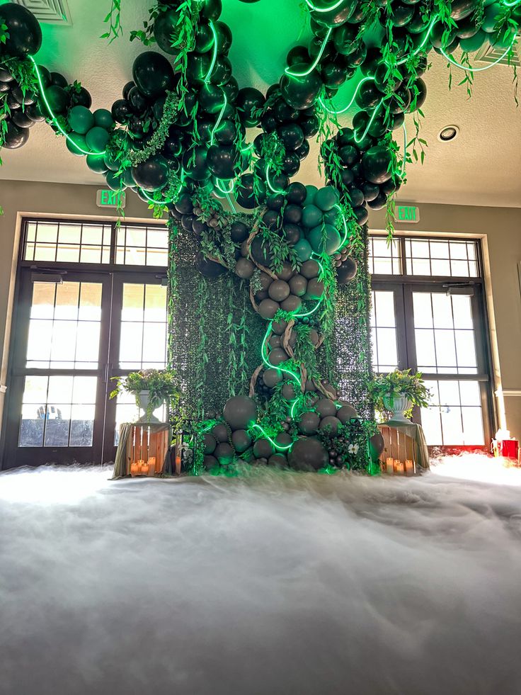 an indoor area with balloons and plants on the ceiling