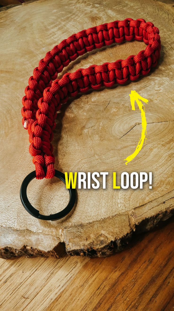 the wrist loop has an arrow on it and is attached to a black ring with a rubber o - ring