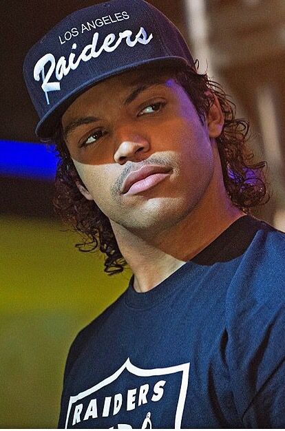 a man with long hair wearing a los angeles football hat and looking at the camera