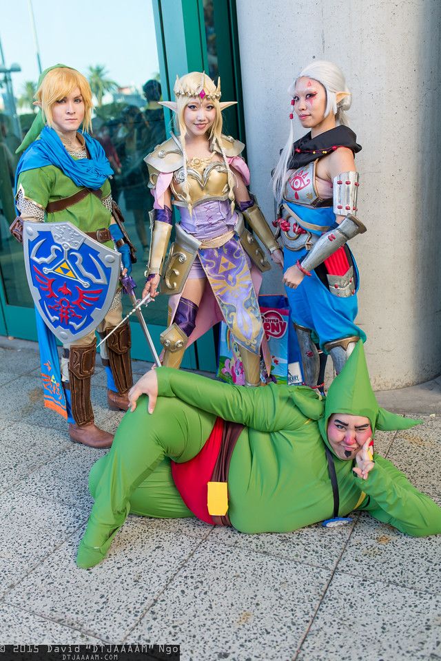 four cosplays dressed in costumes posing for a photo on the ground with one laying down