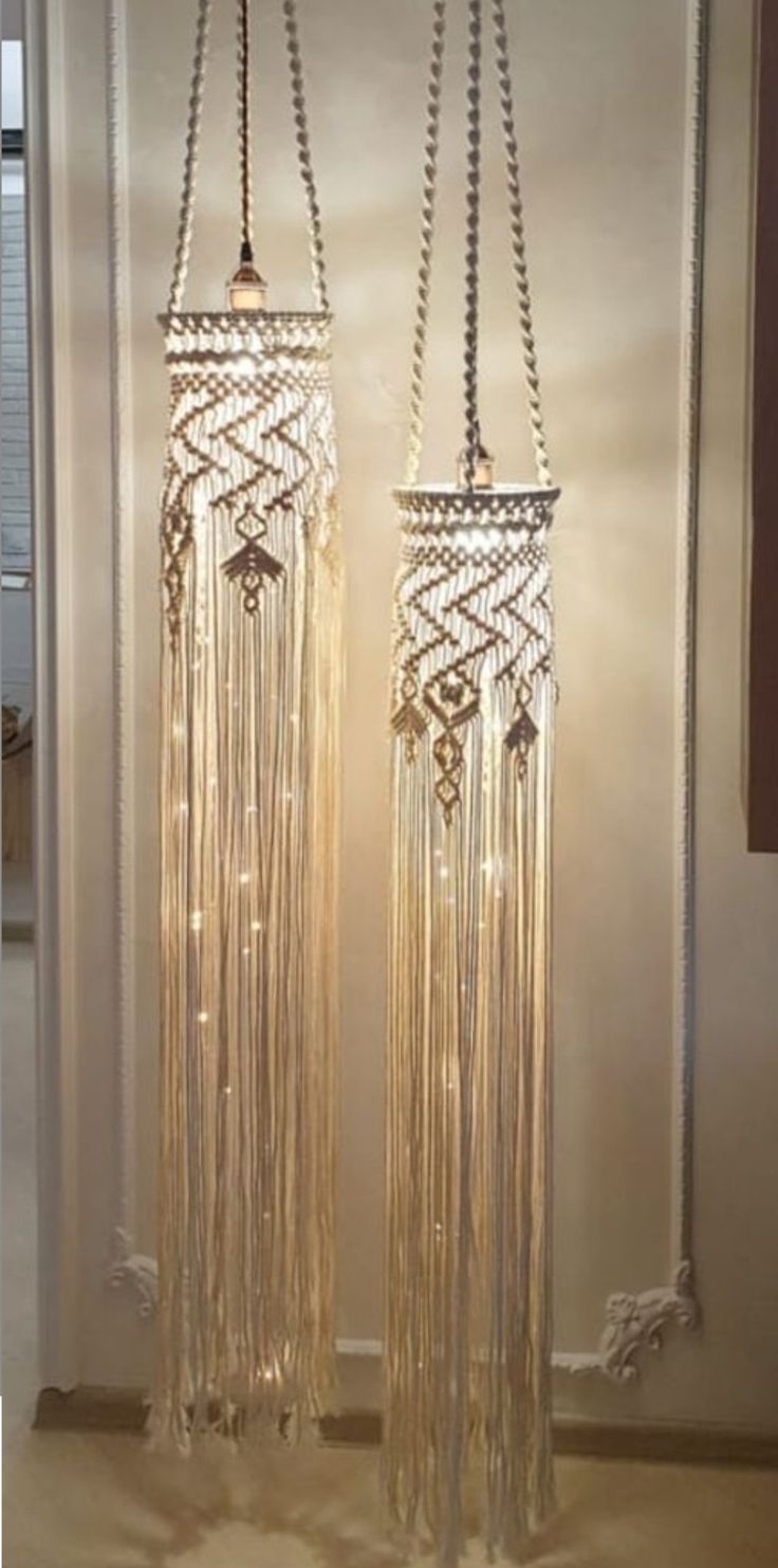 two tall glass chandeliers with chains hanging from them in front of a door