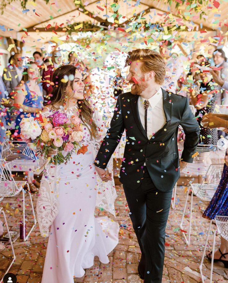 a bride and groom walking through confetti