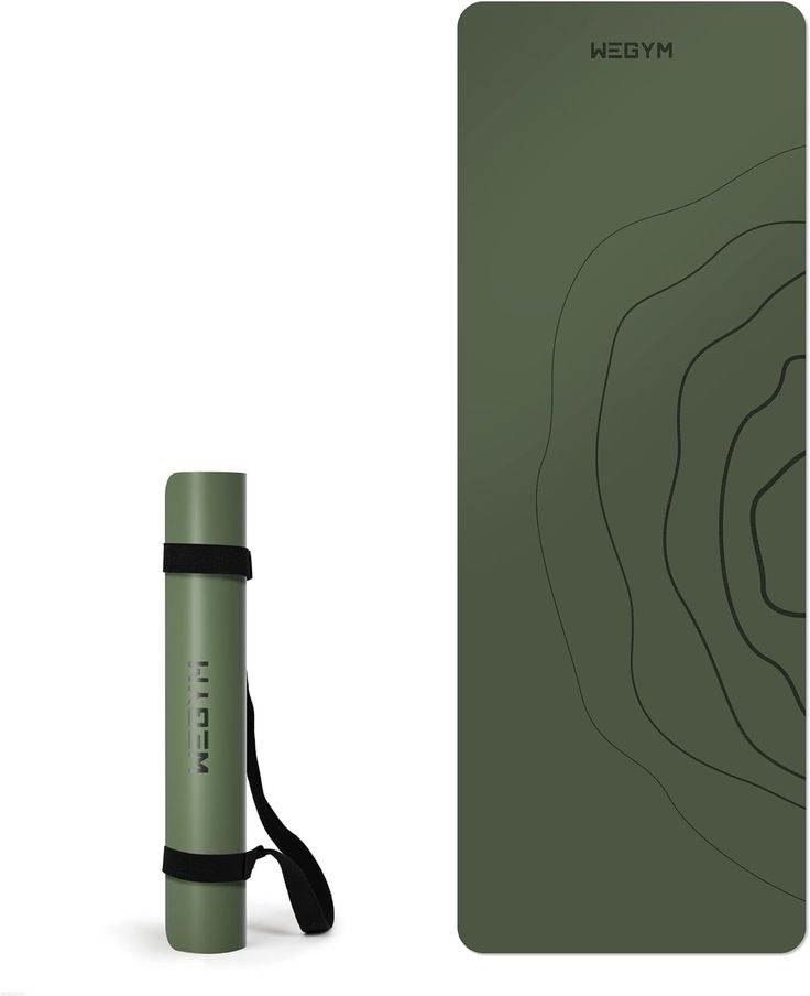 a green yoga mat with a black strap next to it and an empty yoga mat