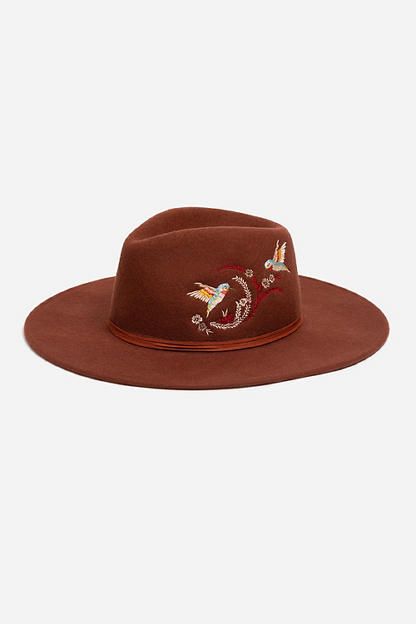 Crafted from 100% wool, the Hummingbird Heather Hat is available in an earthy rust color. Featuring a mid-height crown and a wide brim, this hat is finished with intricate placement embroidery and a decorative feather placed thoughtfully at the hatband. Style with a denim-on-denim look and western style boots for an eclectic ensemble. Women's Hummingbird Feather Hat by Johnny Was in Rust Brown, Denim Hummingbird Feather, Placement Embroidery, Denim On Denim Looks, Brown Denim, Western Style Boots, Feather Hat, Boho Chic Outfits, Women's Blouses, Style Boots