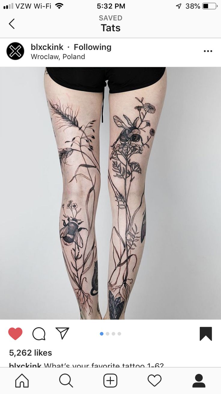 a woman's leg with tattoos on her legs and flowers in the bottom half