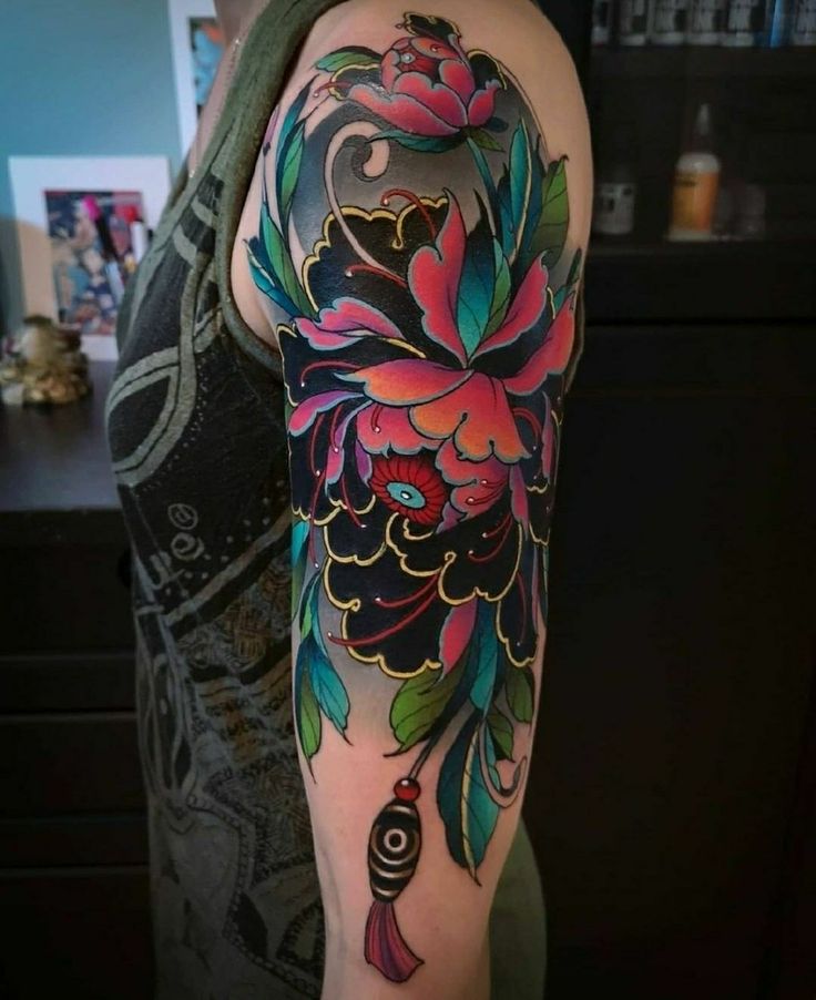 a woman with a colorful flower tattoo on her arm