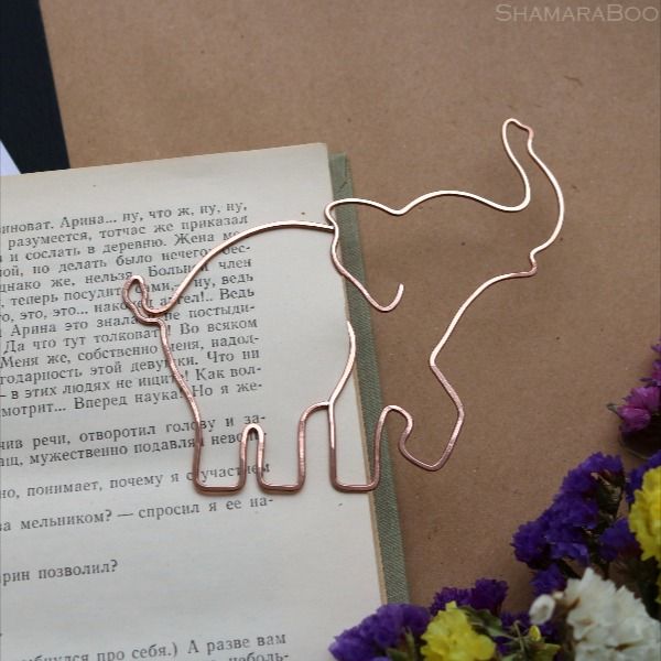 a bookmark with an elephant on it next to flowers