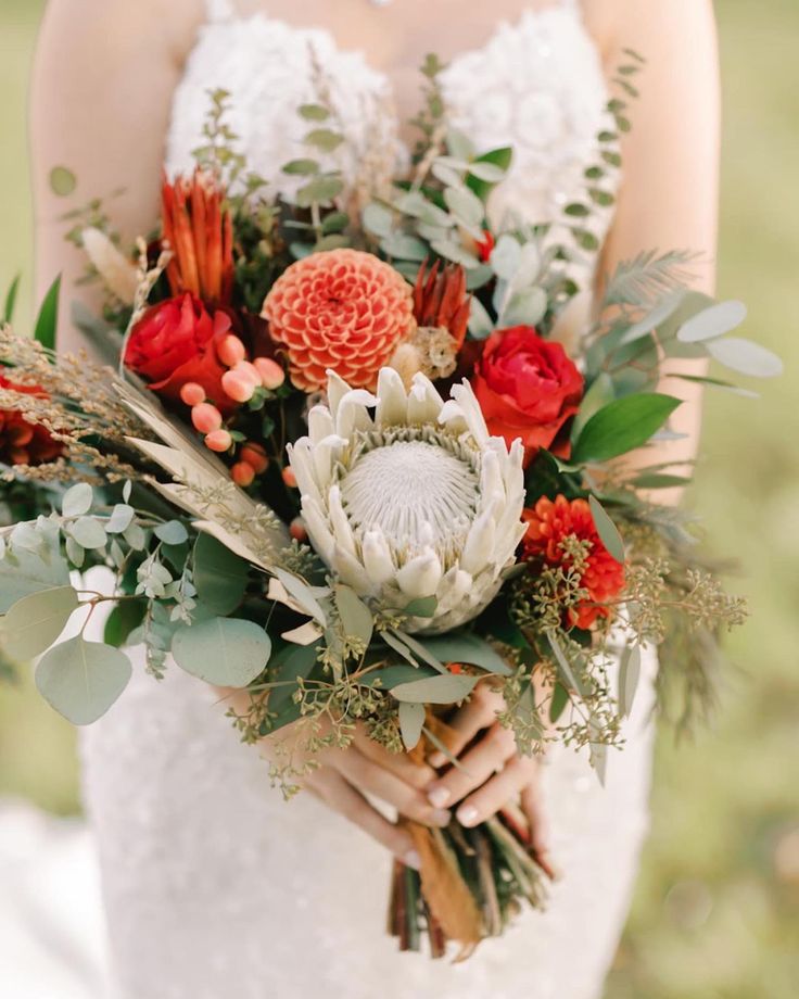 a woman holding a bouquet of flowers in her hands