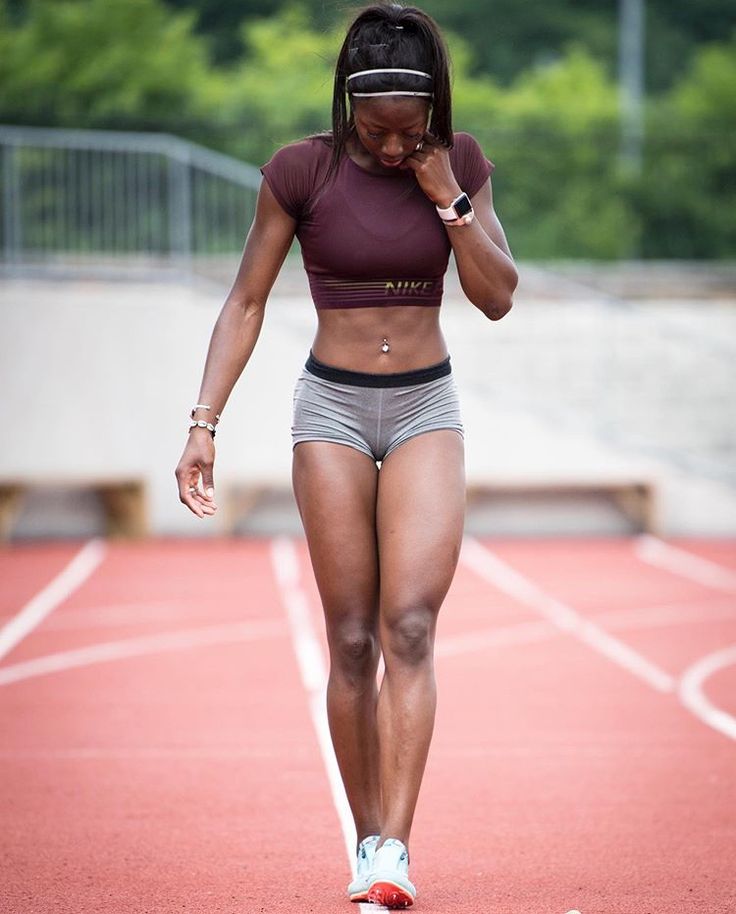 a woman is running on a track and talking on the phone