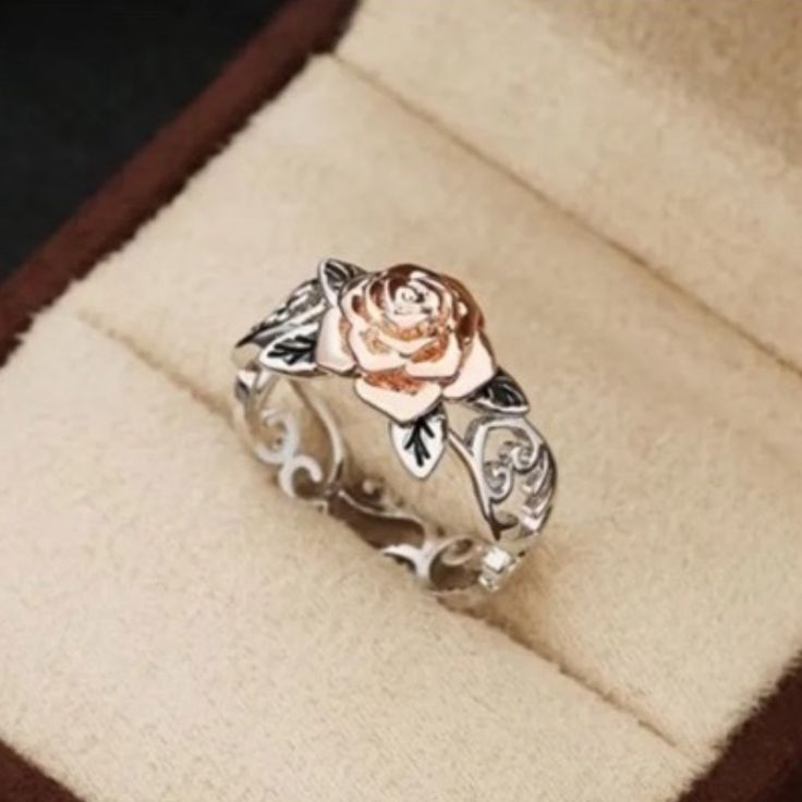 a ring with a rose on it sitting in a box