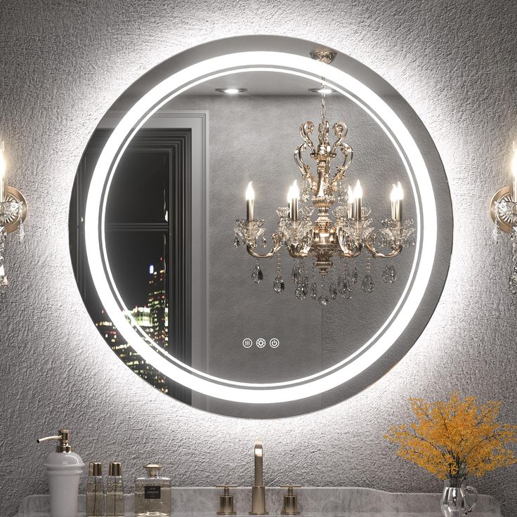 a bathroom sink with a round mirror above it and lights on the wall behind it