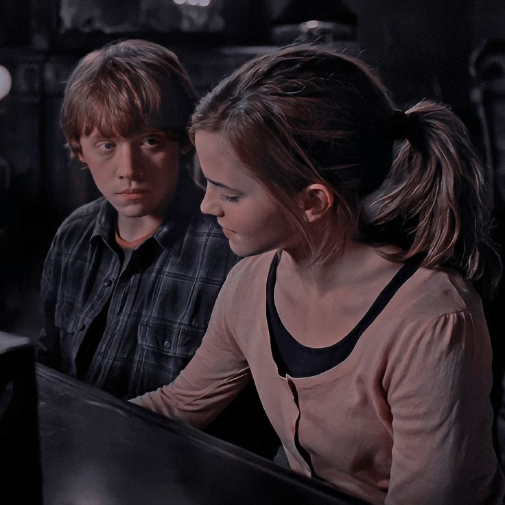 two people sitting at a table looking at a computer screen