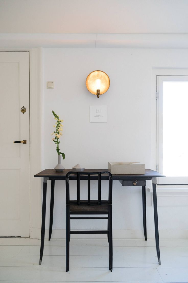 a table with two chairs and a vase on it