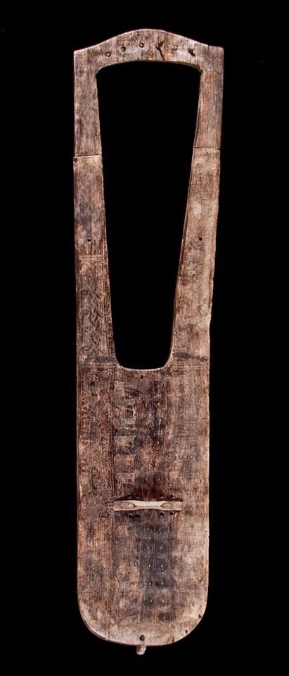 an old wooden cutting board with a hole in the middle on a black background,