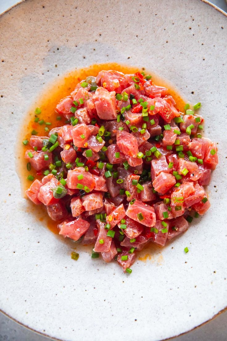 a white plate topped with meat and green onions