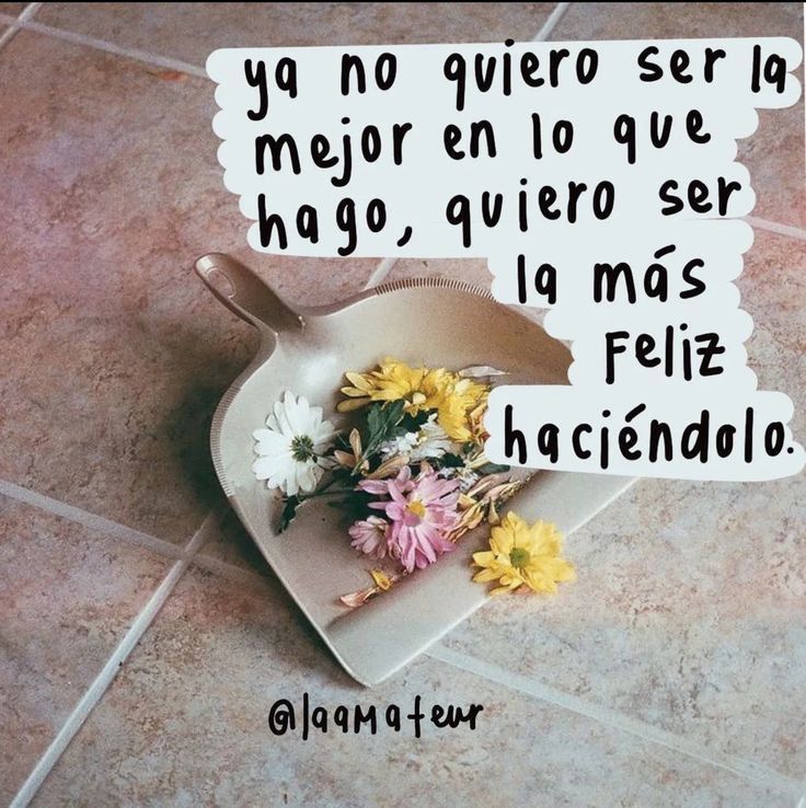 a heart shaped dish with flowers in it on a tile floor next to a sign that reads, no quiero ser la mejo eno que que que que ha goe hago, que