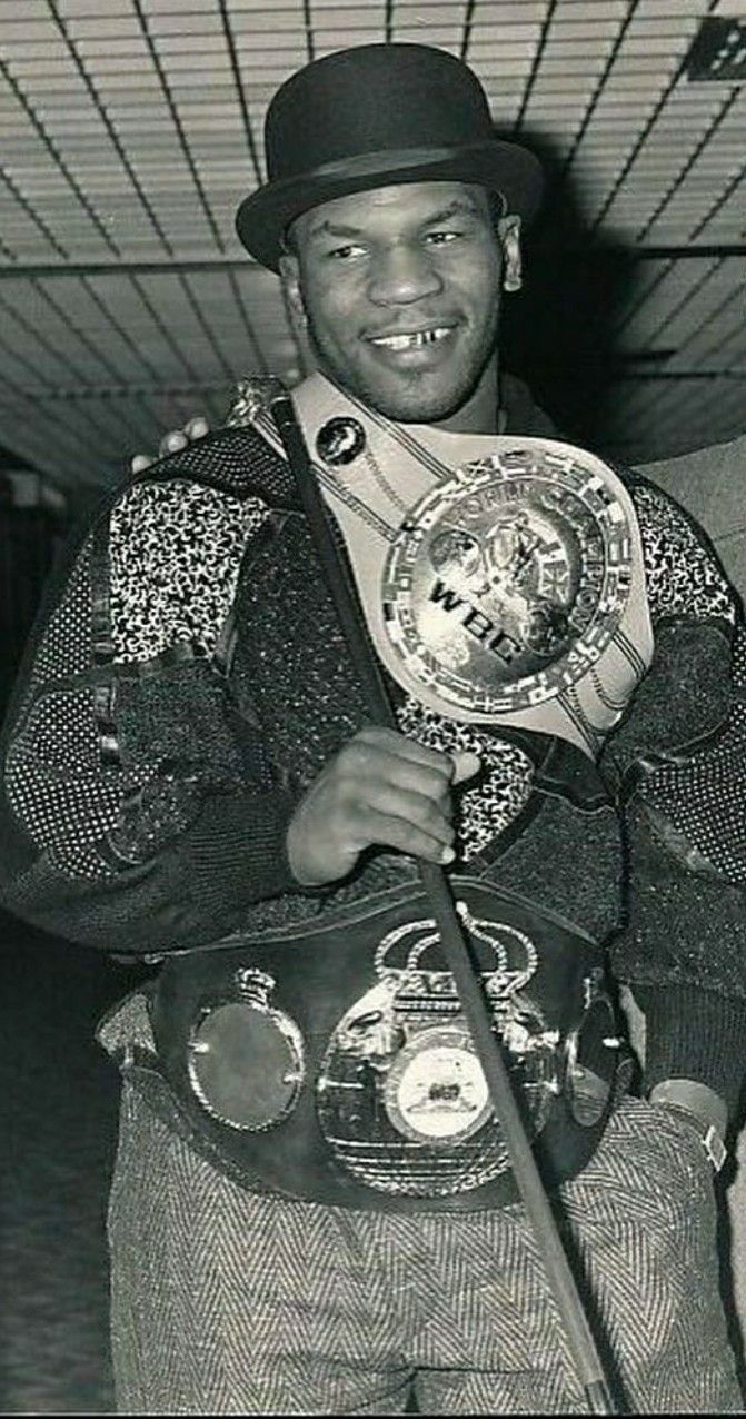 a black and white photo of a man holding a boxing ring in his hands while standing next to another man