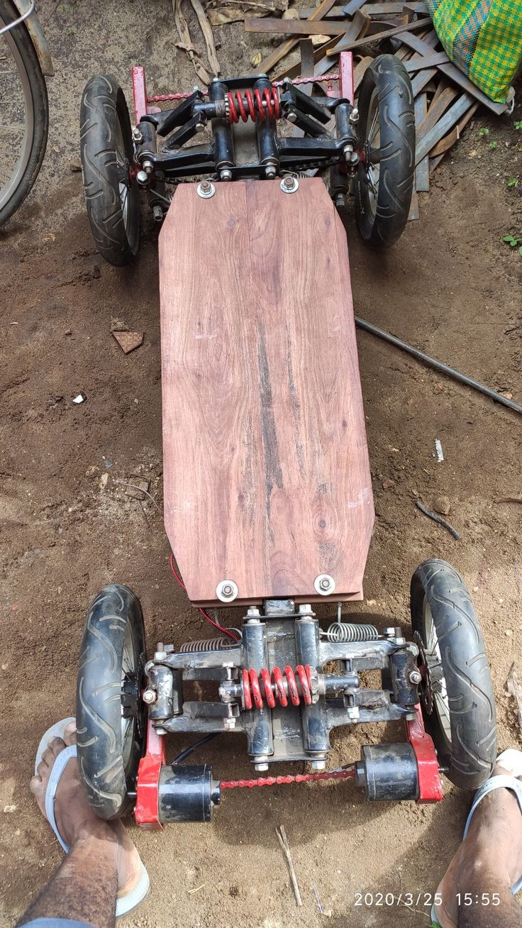 a person is sitting on the ground next to an upside down skateboard that has been made out of wood