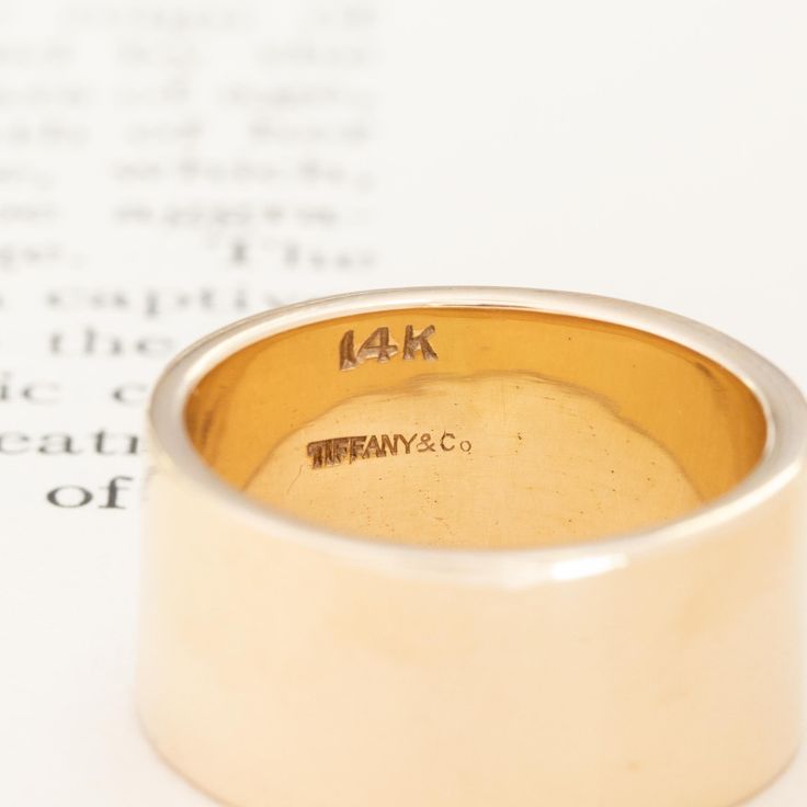 Chic and timeless cigar band from Tiffany & Co! She is the perfect index finger or middle finger ring and better yet, an engagement band or wedding band. Unique and one of a kind - she slips on like buttah on the finger! 14kt yellow gold Size 7.5 & resizable with limitations 10.4mm in width & 1.33mm thick 12.1 grams Please see qualitative report for more information. Timeless Wide Band Wedding Bands, Timeless 14k Gold Wide Band Ring For Anniversary, Timeless Yellow Gold Wide Band Ring, Timeless Yellow Gold Wide Band Wedding Ring, Timeless Thick Band Ring For Anniversary, Wedding Wide Band Signet Ring In Fine Jewelry Style, Engraved Wide Band Ring Stamped 14k For Wedding, Engraved 14k Gold Wide Band Ring For Wedding, Engraved 14k Gold Wide Band Ring For Anniversary