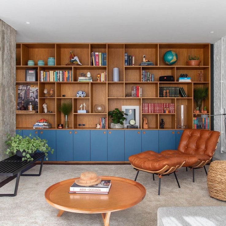 a living room filled with furniture and bookshelves next to a wall full of shelves