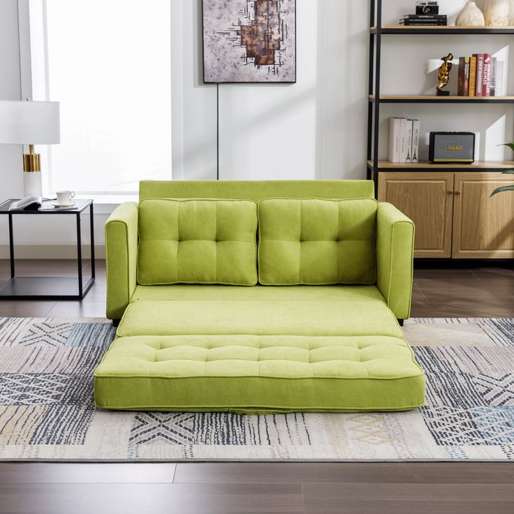 a green couch sitting on top of a rug in a living room