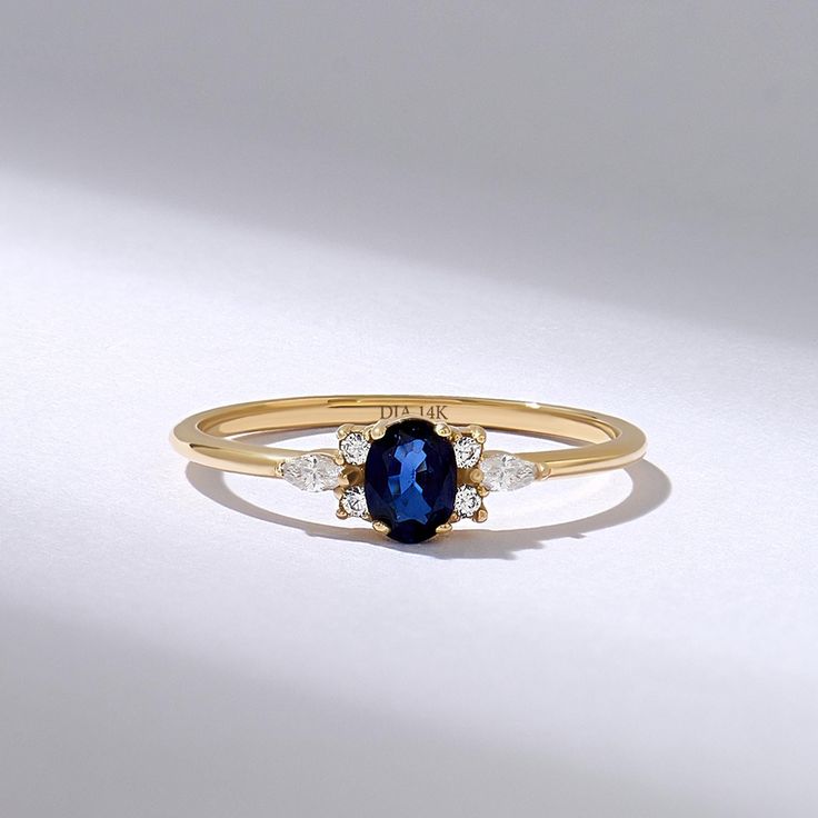 This captivating engagement ring features a lustrous navy blue gemstone at its center, accented by sparkling brilliant diamonds. The exquisite combination of the oval sapphire and shimmering diamonds creates a timeless and elegant design, perfect for symbolizing love and commitment.  𝐈𝐭𝐞𝐦 𝐃𝐞𝐭𝐚𝐢𝐥𝐬 * Gold KT: 10K, 14K, 18K * Custom Gold Color: Rose Gold, Yellow Gold, White Gold * Top of Band: 4.95MM * Width of Band: 1.30MM * Thickness of Band: 1.10MM * Total Ctw: 0.37 ctw  𝐆𝐞𝐦𝐬𝐭𝐨? Blue Diamond Ring With 14k Gold Accents, Elegant Blue Diamond Ring For Proposal, Blue Diamond Ring With Gemstone Accents, Blue Diamond Promise Ring With Accents, Fine Jewelry Sapphire Birthstone Ring With Gemstone Accents, Promise Ring With Sapphire And Gemstone Accents, Blue Diamond Ring With Gemstone Accents For Promise, Sapphire Birthstone Ring With Gemstone Accents For Promise, Sapphire Birthstone Ring With Gemstone Accents